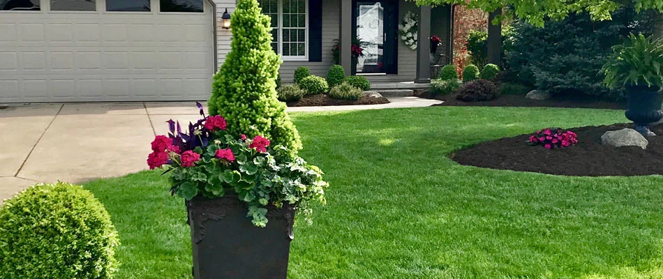 Spring annuals planted in a pot and landscaping bed at a residential property in Huron, OH.